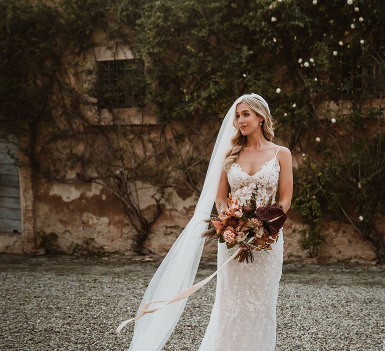 Bride wears romantic lace Emmy Mae Bridal wedding dress and Made With Love Bridal cathedral veil  