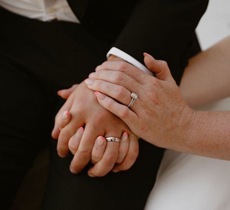 Bride wears diamond engagement ring and neutral nail varnish with pink tips 