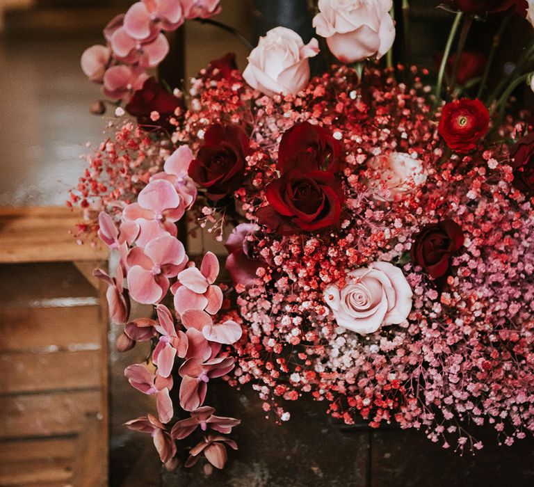 Pink, red and magenta roses, orchids and gypsophila 