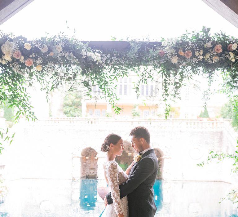 Bride and groom stand embracing each other for the outdoor wedding ceremony 