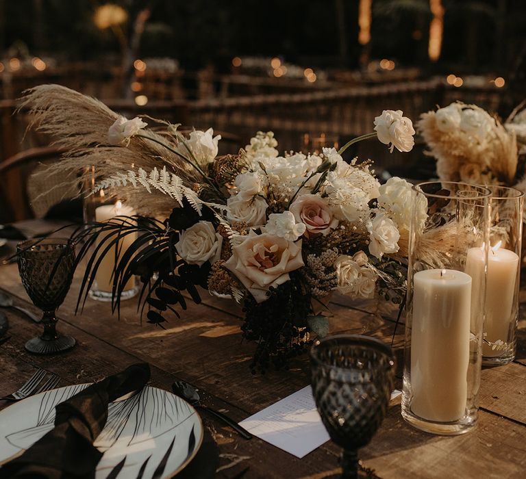 Rustic wooden tables complete with floral arrangements and white pillar candles