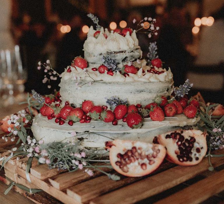 Homemade wedding cake complete with strawberries, pomegranate and white frosting 