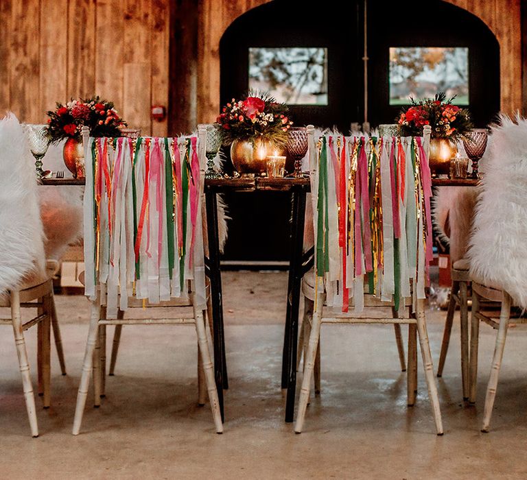 Wedding cane seating at rustic wedding tablescape with white, forest green, gold, baby pink and hot pink wedding streamers on the back