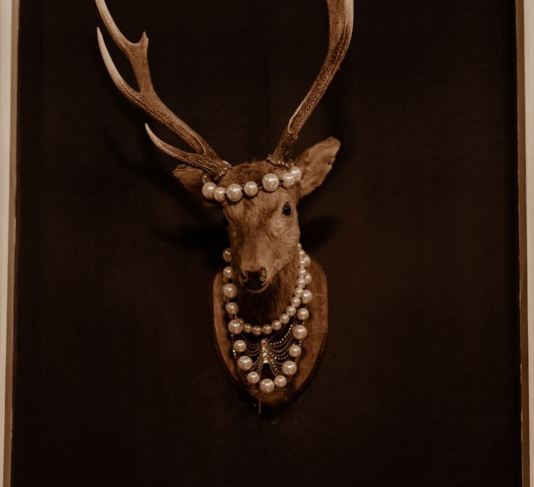 Stag head taxidermy decoration with pearls attached to it for the wedding 