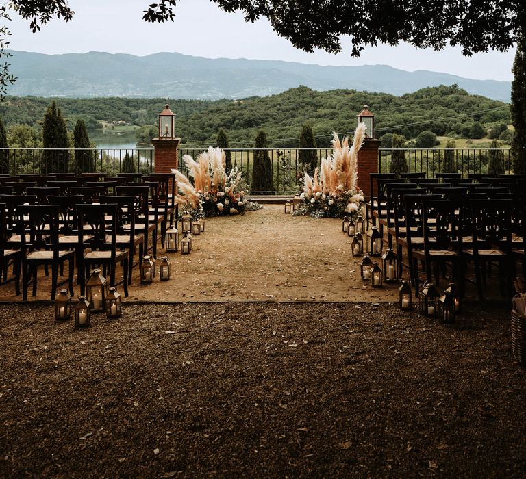 Italian wedding ceremony is Tuscany with pampas grass decor and views of the Tuscan hills