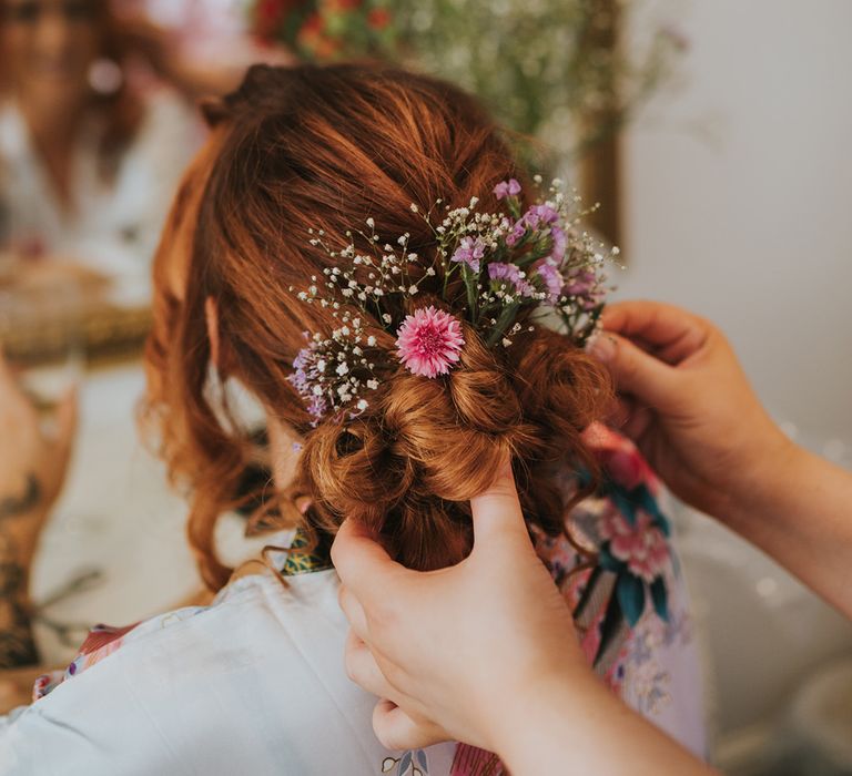 pinned bridal up do with fresh flowers in her hair 