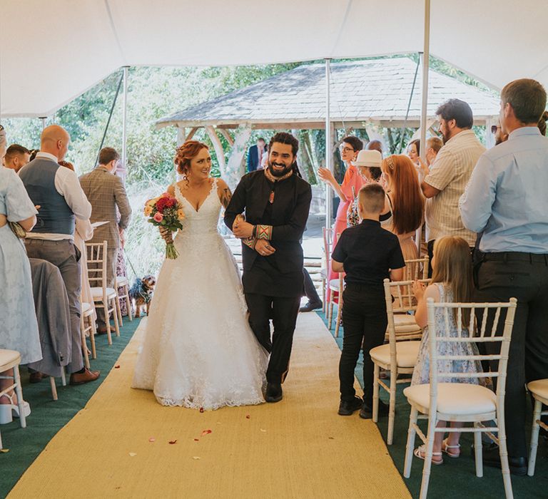 bride and groom descending up the aisle as husband and wife 