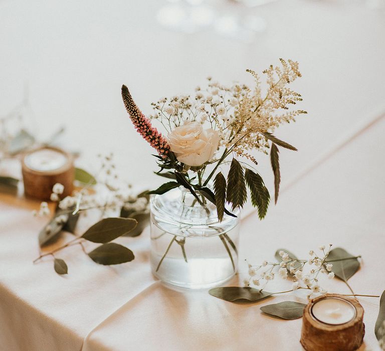 Small bud vase with pretty white and pink wedding flowers for the table decorations 