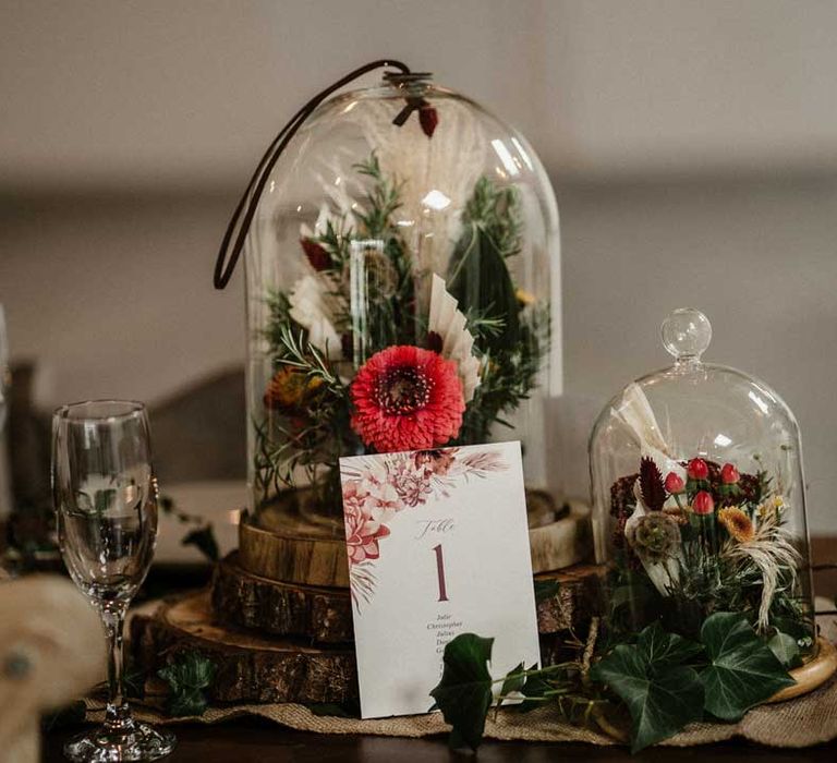 Glass dome wedding centrepiece decorations on tree stump circles with botanical luxe wedding table numbers 