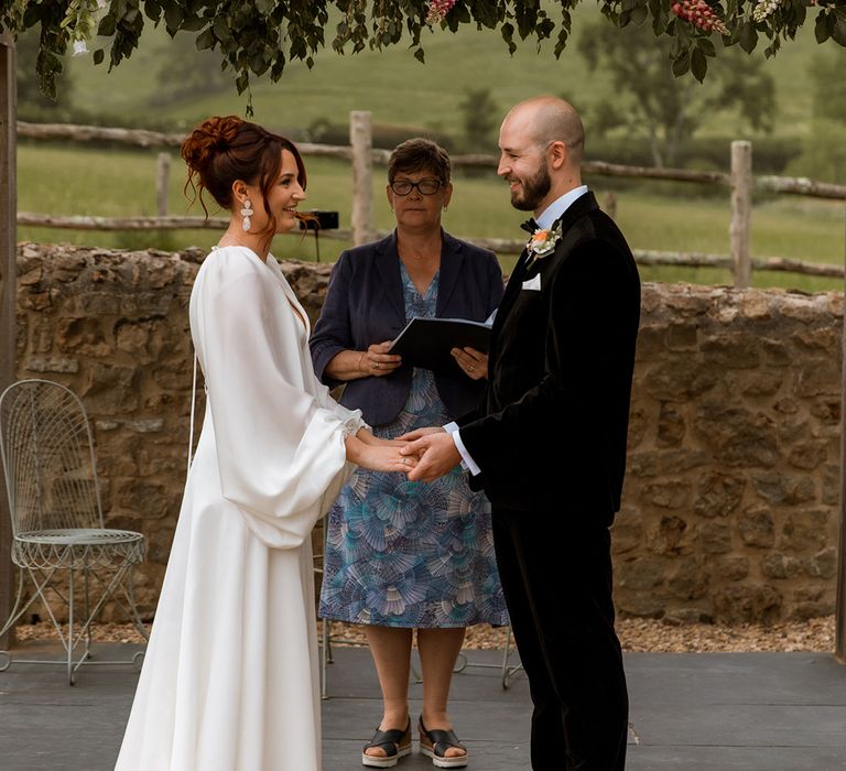 Outdoor wedding ceremony with bride and groom at their black tie retro wedding 