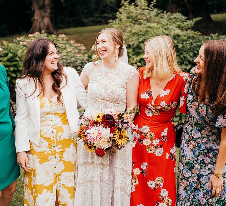 Bridesmaids in bright floral mismatched dresses for the wedding day at Coombe Lodge 