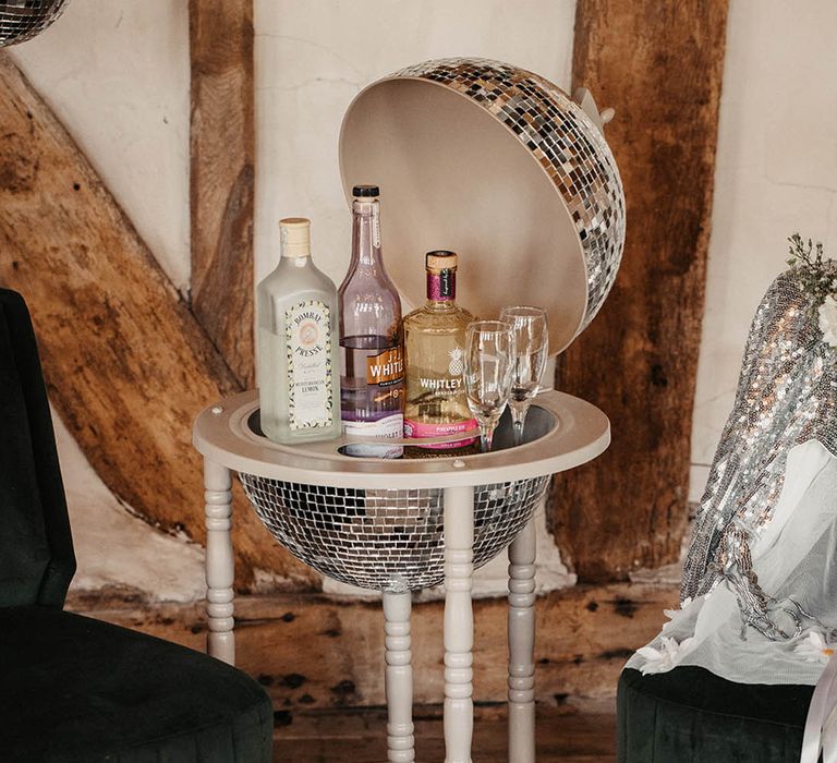 Disco ball wedding drinks trolley with bottles of alcohol inside 