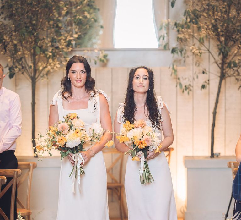 White bridesmaid dresses and yellow wedding flowers