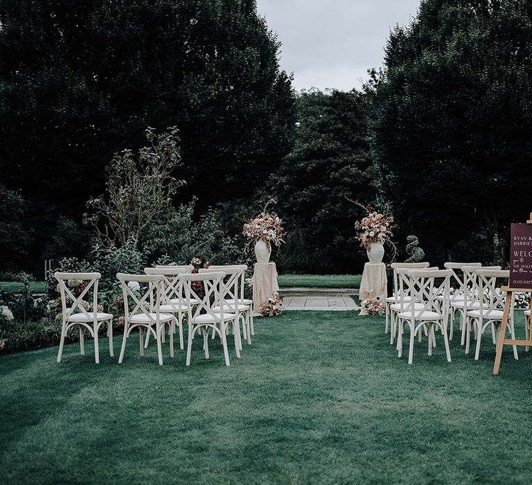 Outdoor garden wedding at The Holford Estate wedding with two pillars with autumnal wedding flower arrangements 