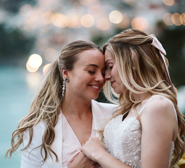 Two brides embrace for romantic couple portrait photo at same sex wedding 