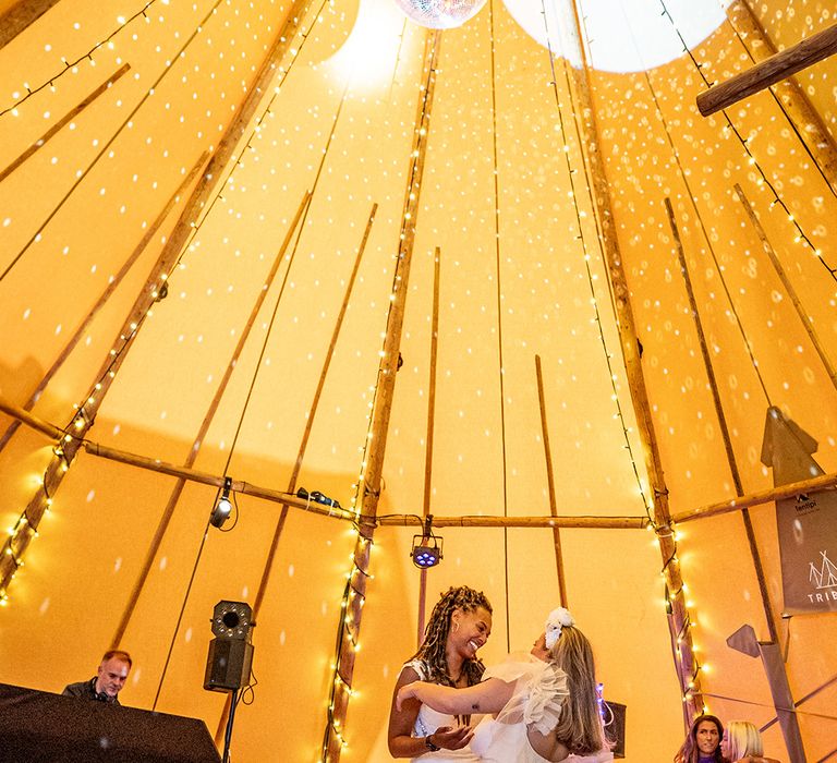 Lesbian wedding with two brides having their first dance at tipi wedding 