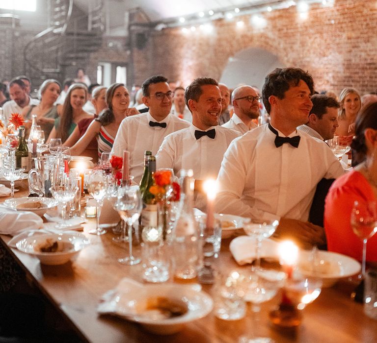 Groomsmen sitting at the banquet tables for the wedding breakfast 