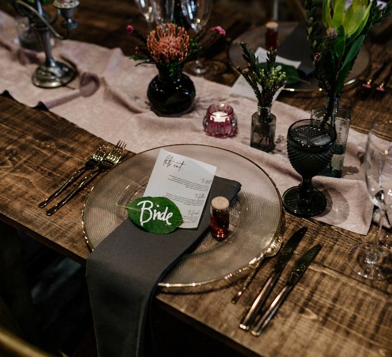 Place setting with glass charger plate and leaf name place card.