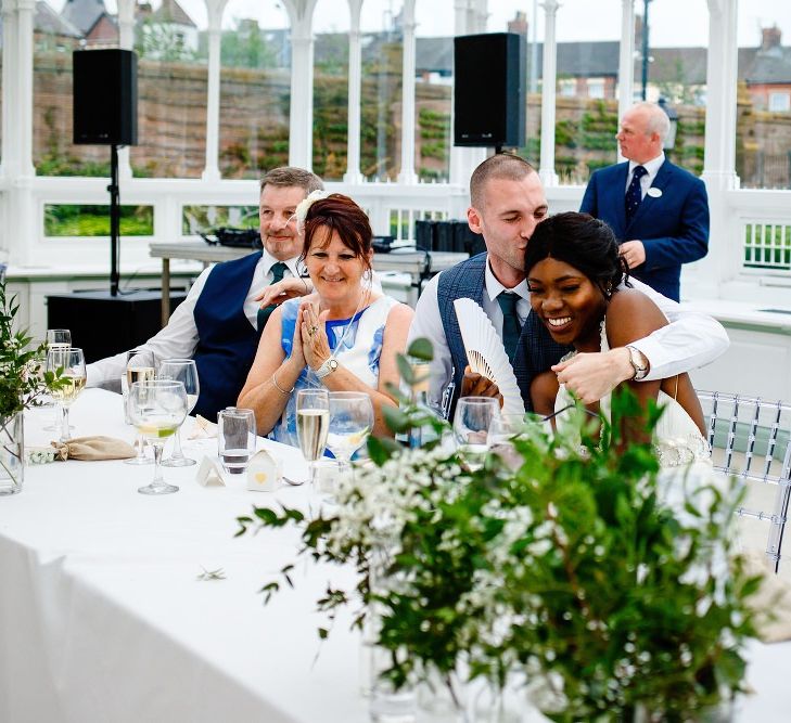 Groom kissing his bride at the top table 