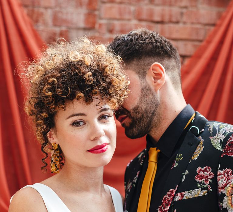 bride with curly hair, red lipstick and tortoise shell earrings 