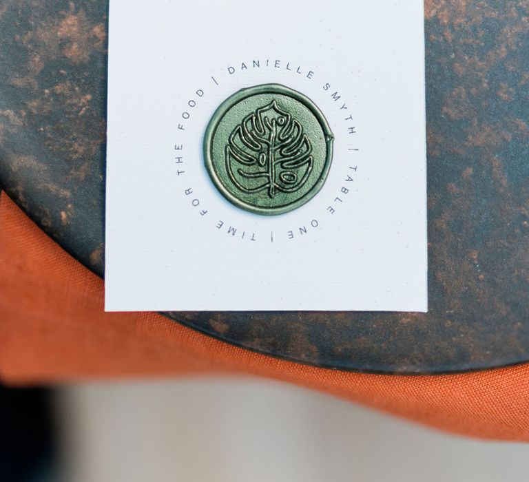 Minimalist wedding stationery with leaf wax seal on rustic tableware