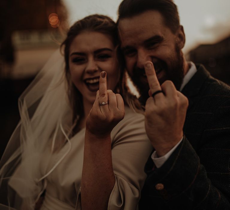 Bride and groom show off their wedding rings