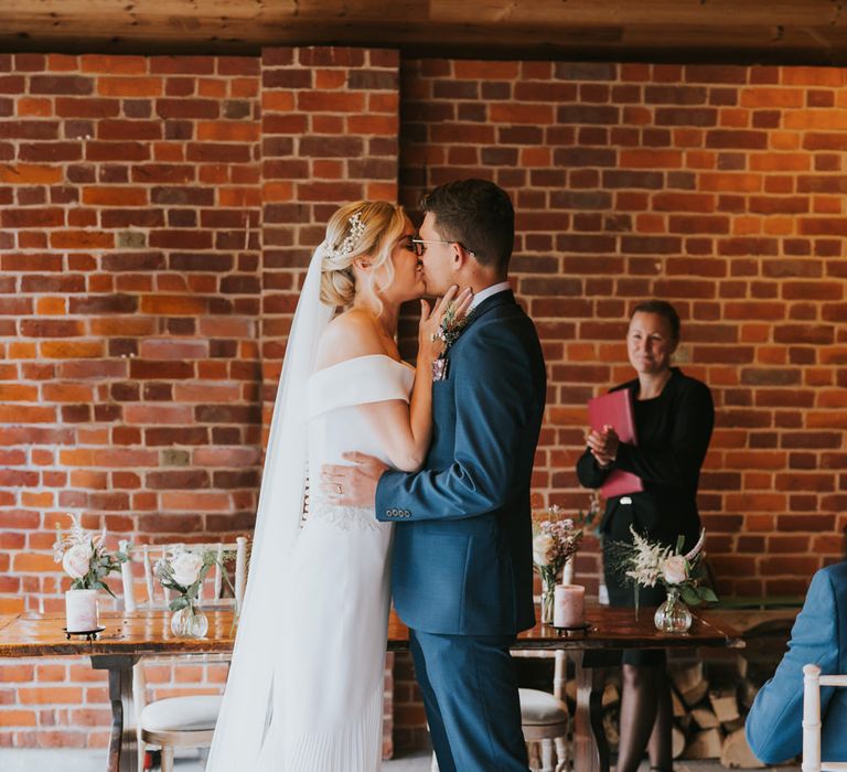 Bride & groom kiss during wedding ceremony