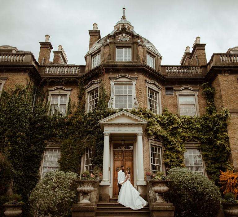 Bride and groom portrait outside their historic Hampton Court House wedding venue 