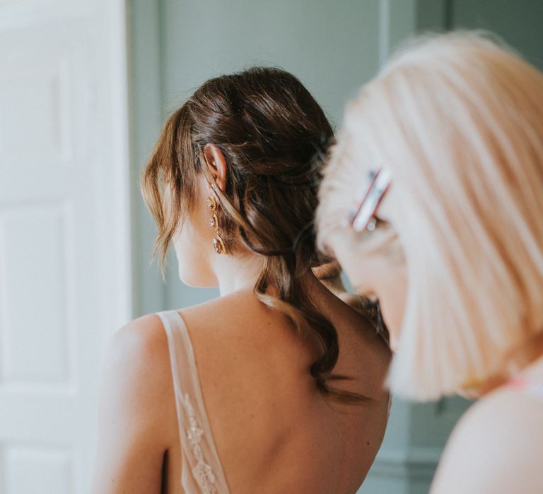 Bride has her dress done up on the morning of her wedding