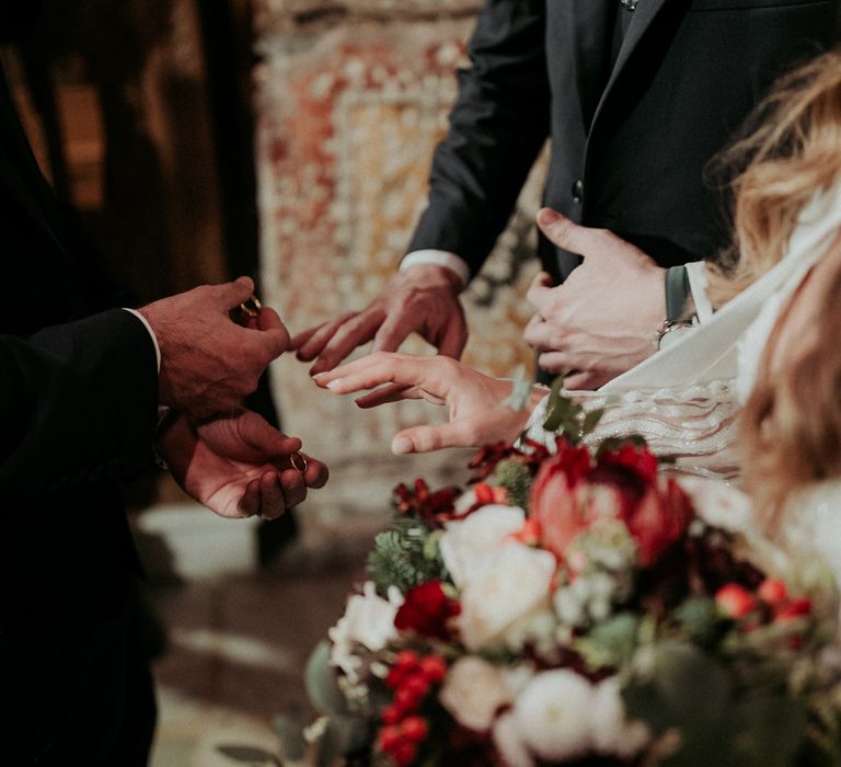 Exchanging wedding rings at their church ceremony