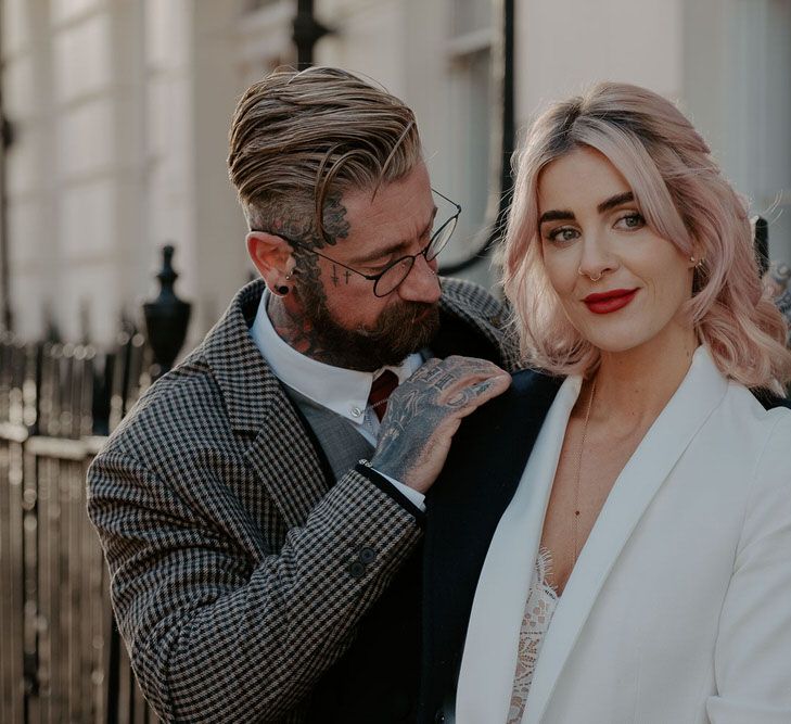 Groom puts coat on shoulders of bride in suit jacket