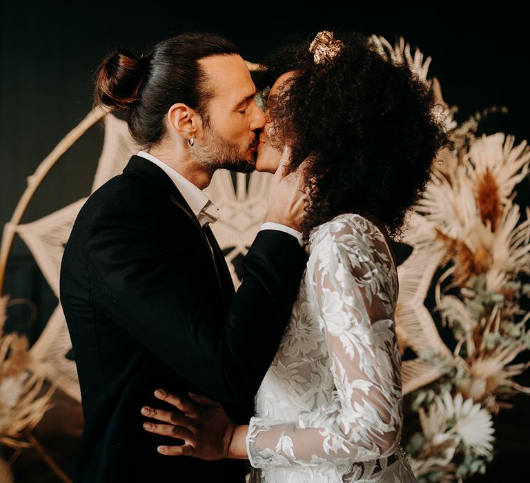 Groom kisses bride during wedding ceremony