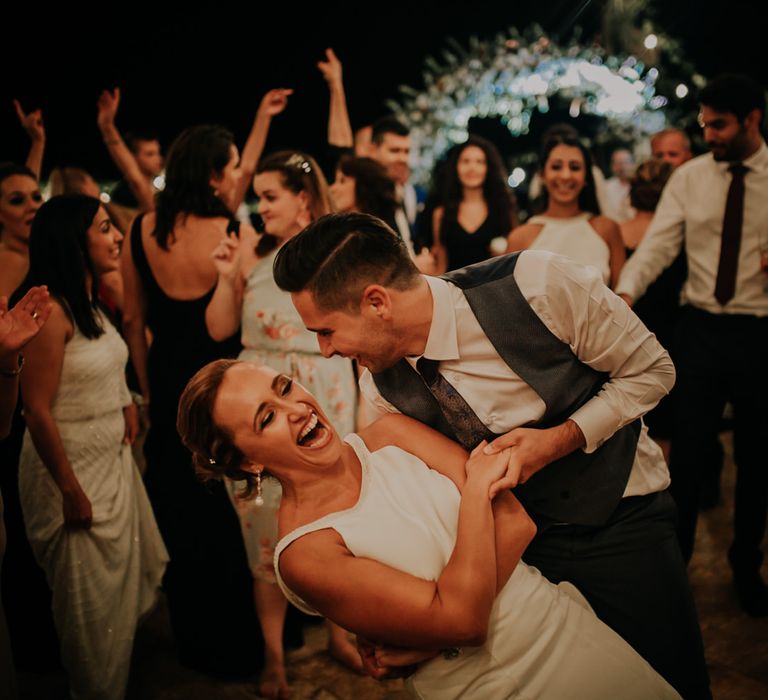 The groom dipping a female guest on the dancefloor