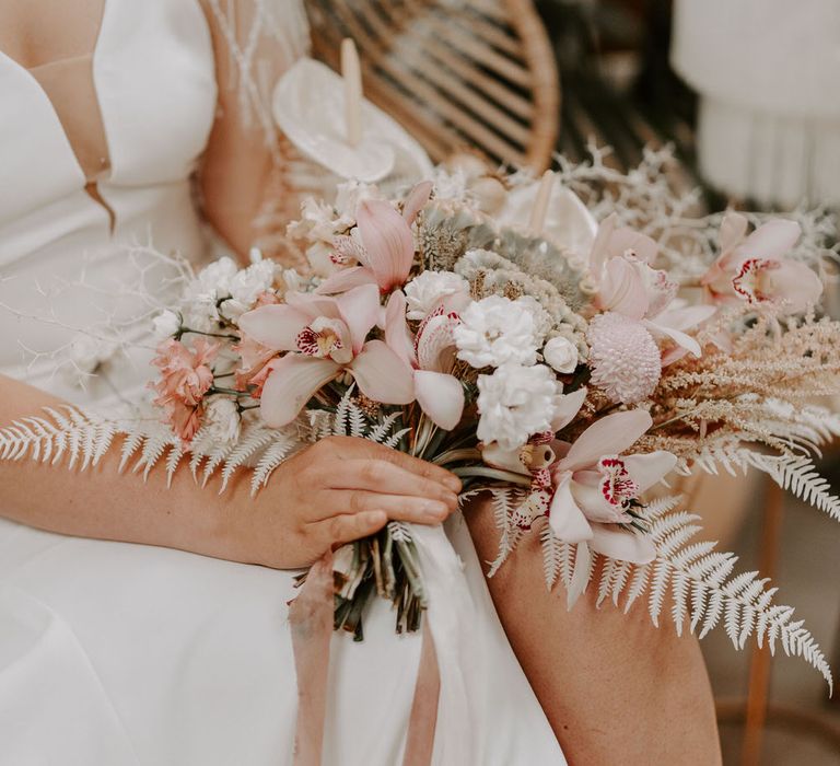 Tropical wedding bouquet with pink and white flowers including chrysanthemums, lilies, anthuriums and white ferns