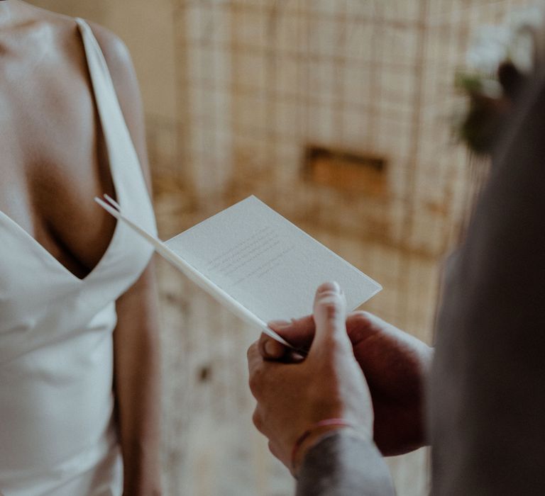 A grooms reads his vows for a booklet. 