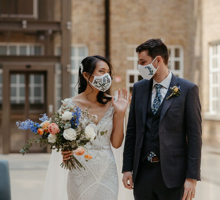 Bride and groom wearing white floral face masks for their micro-wedding at Hackney Town Hall