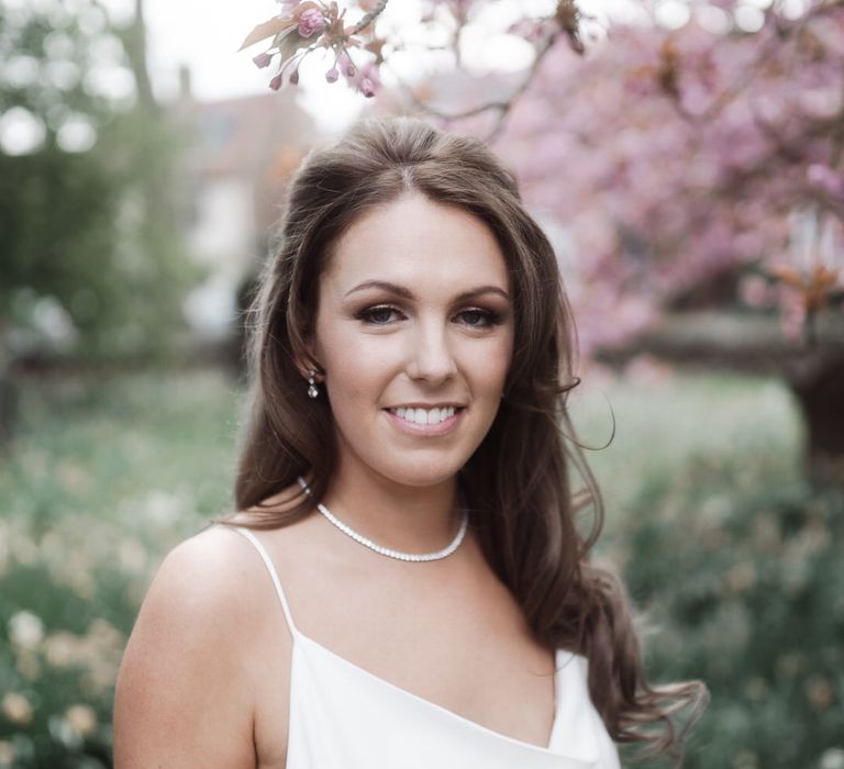 Bride wearing a white slip wedding dress, loose curls and natural makeup