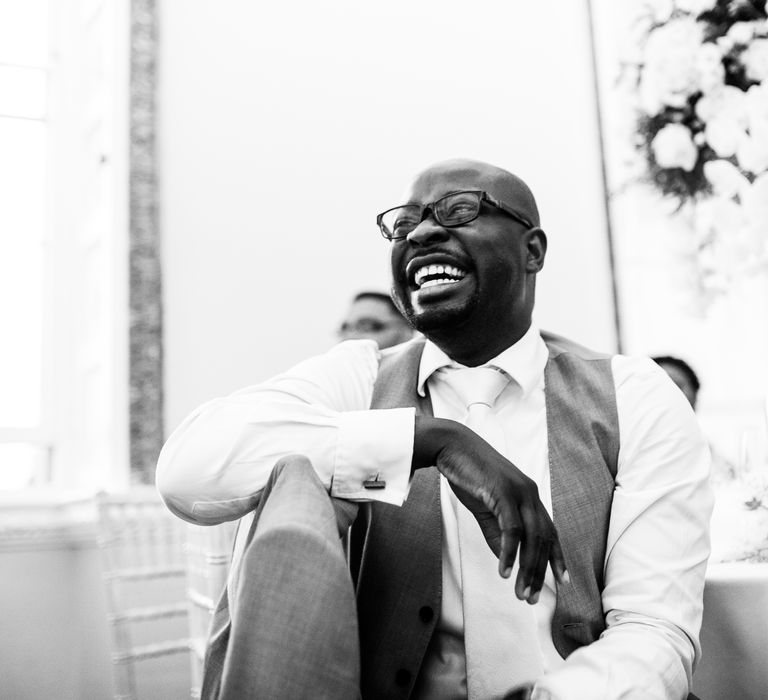 Wedding guests laugh in black & white image