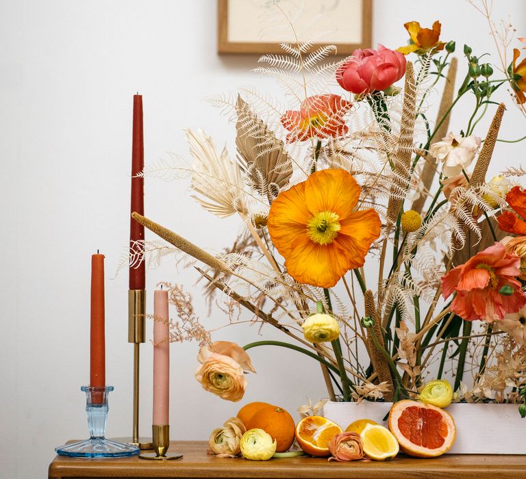 Autumnal colour tapered candles with orange, yellow and dried flower display