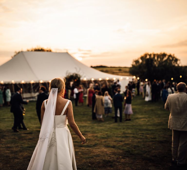 Bride walks towards DIY marquee wedding