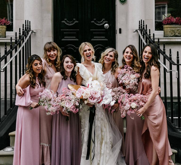 Bridal party portrait with bridesmaids in different fabric and style dresses including a wrap bridesmaid dress with straps