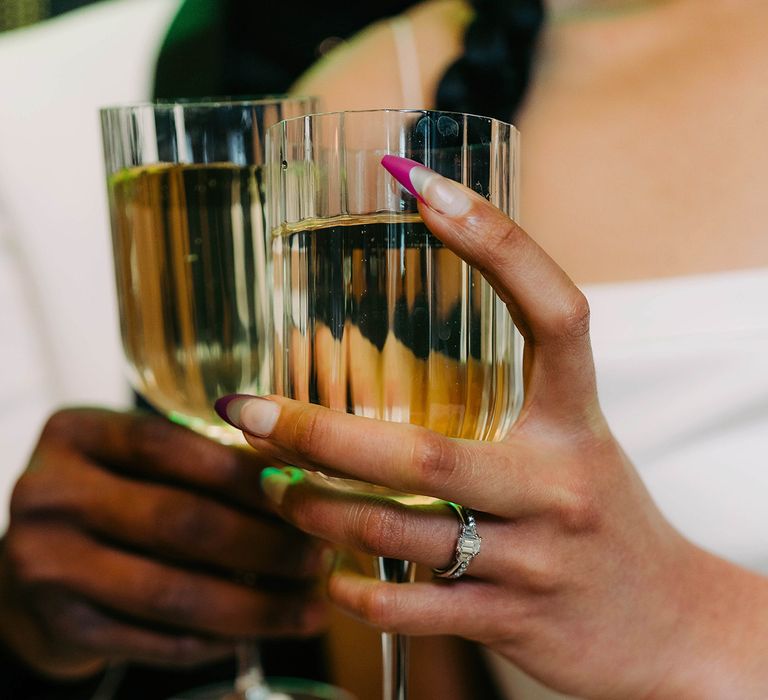 Bride & groom cheers champagne whilst bride wears diamond ring | W Hotel Rock N Roll Bride Magazine