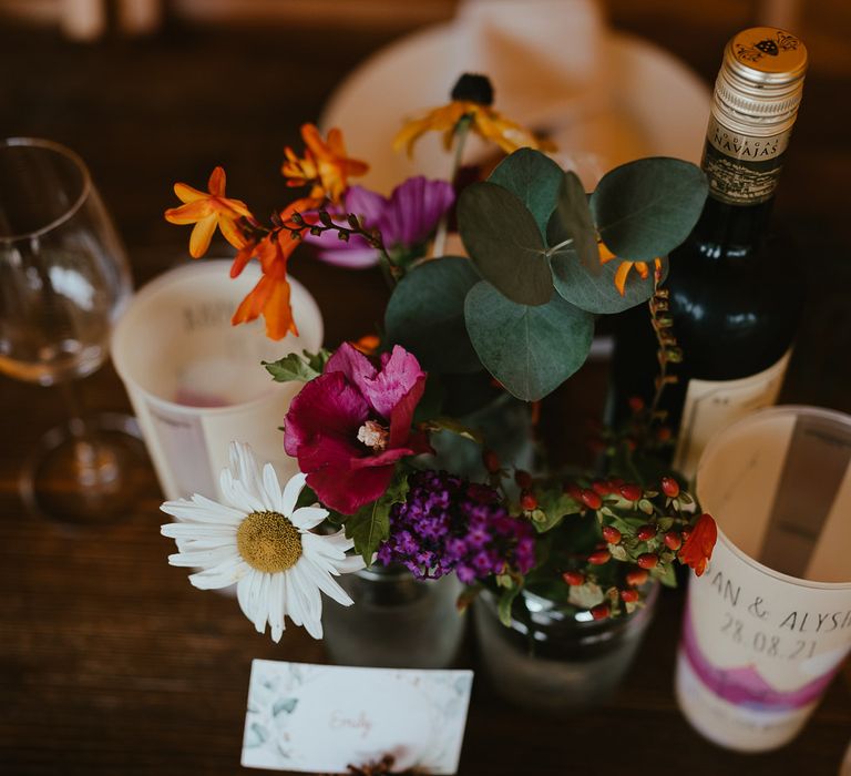 Pink, orange and green florals, wine and personalised resusable cups for tipi wedding reception at Wellington Wood Norfolk for late summer wedding