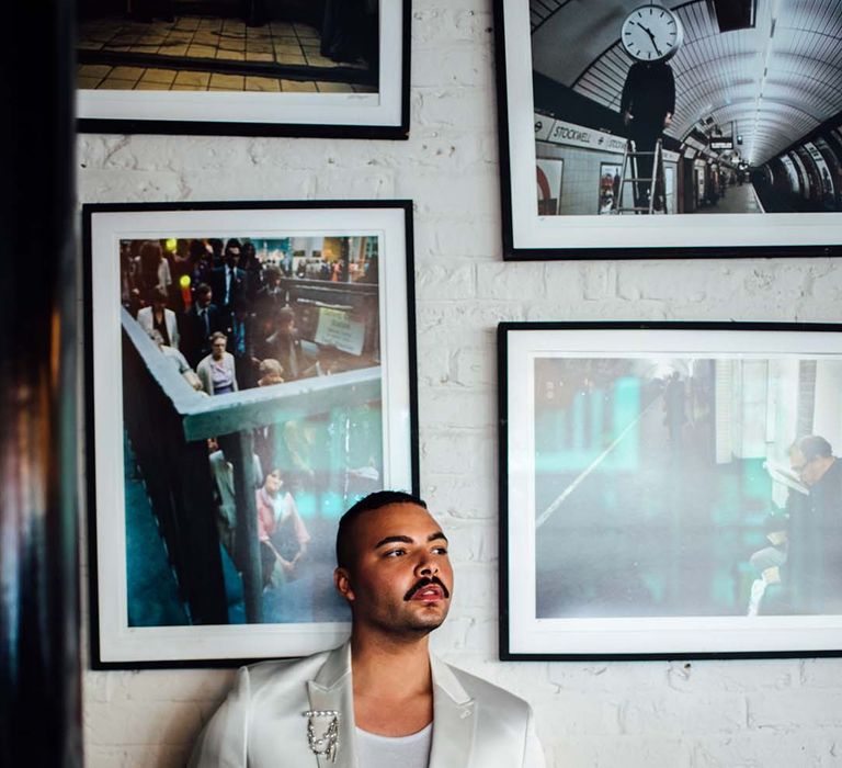 Groom in a white satin double breasted jacket and black leather trousers 