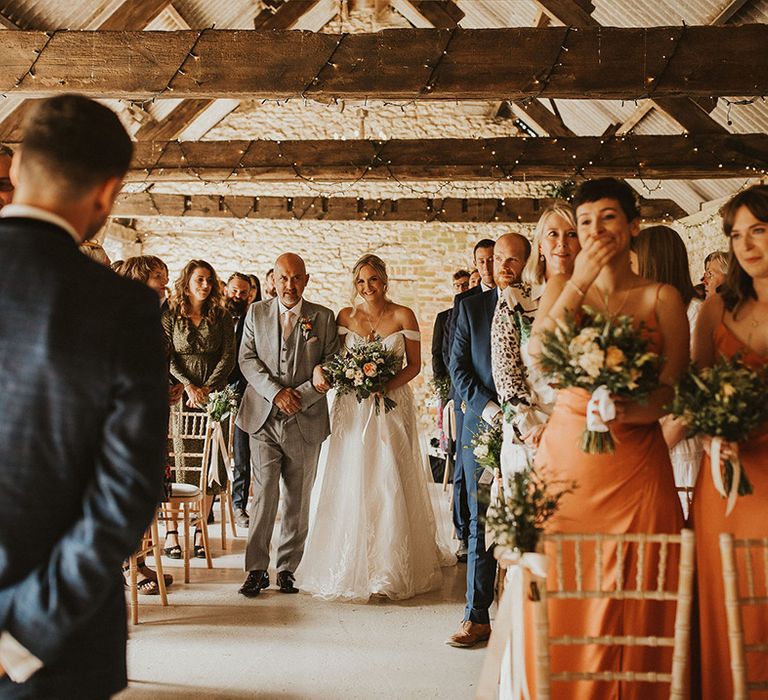 Bride walks down the aisle at barn wedding venue