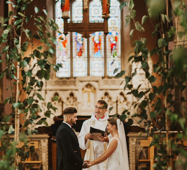 Bride and groom holding hands at the altar of their church wedding ceremony 