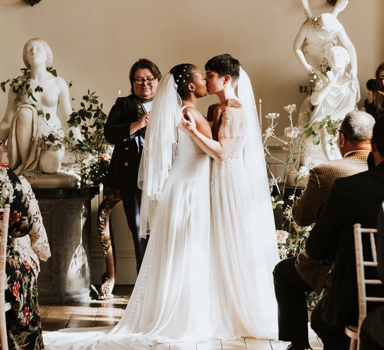 Two brides kissing at their Elmore Court wedding ceremony 