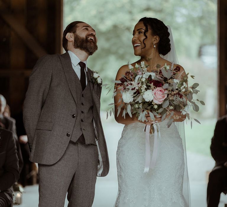 Bride smiles and laughs with her groom during wedding ceremony