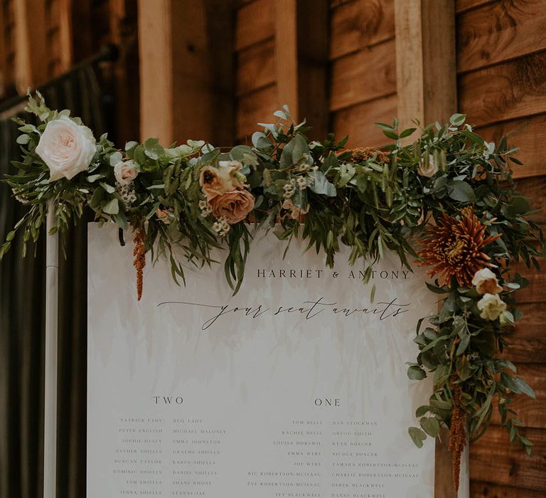 Monochrome table plan at wedding with flower and foliage decor