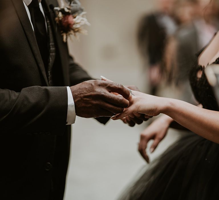 Bride & groom exchange wedding rings during ceremony